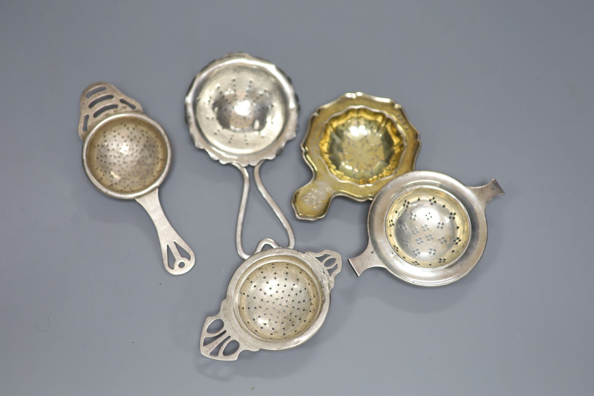 Five assorted 20th century silver tea strainers, 4oz.